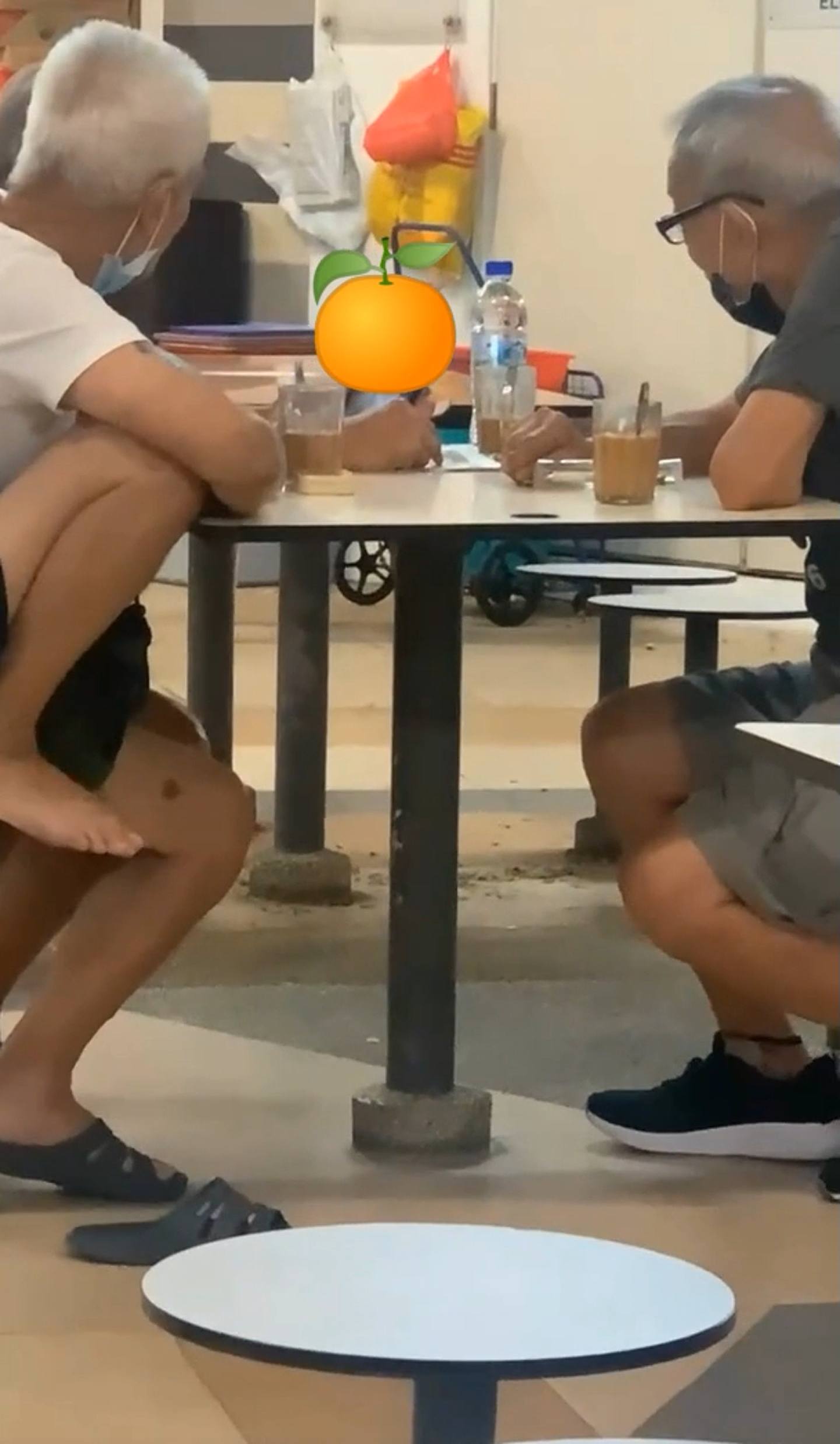 新加坡3名銀髮伯伯公然在熟食市場，用手機觀賞成人片段，據稱曾有途人上前勸喻，但還是繼續全心欣賞。（影片截圖）