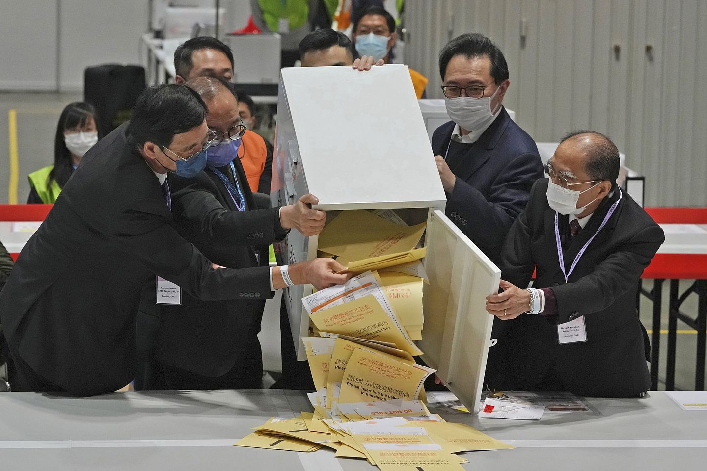 2021年12月19日，香港立法会选举举行，香港选举管理委员会冯骅（右二）和其他官员在投票站清空投票箱清点选票。（AP）