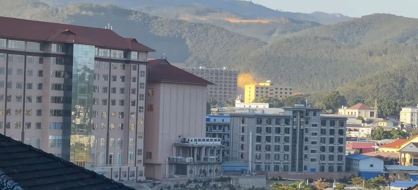 照片摄于12月10日佤邦邦康，老陈目前所在的隔离酒店窗外之景，老陈指，照片中稍高些的楼都是电骗集团的。（受访者供图）