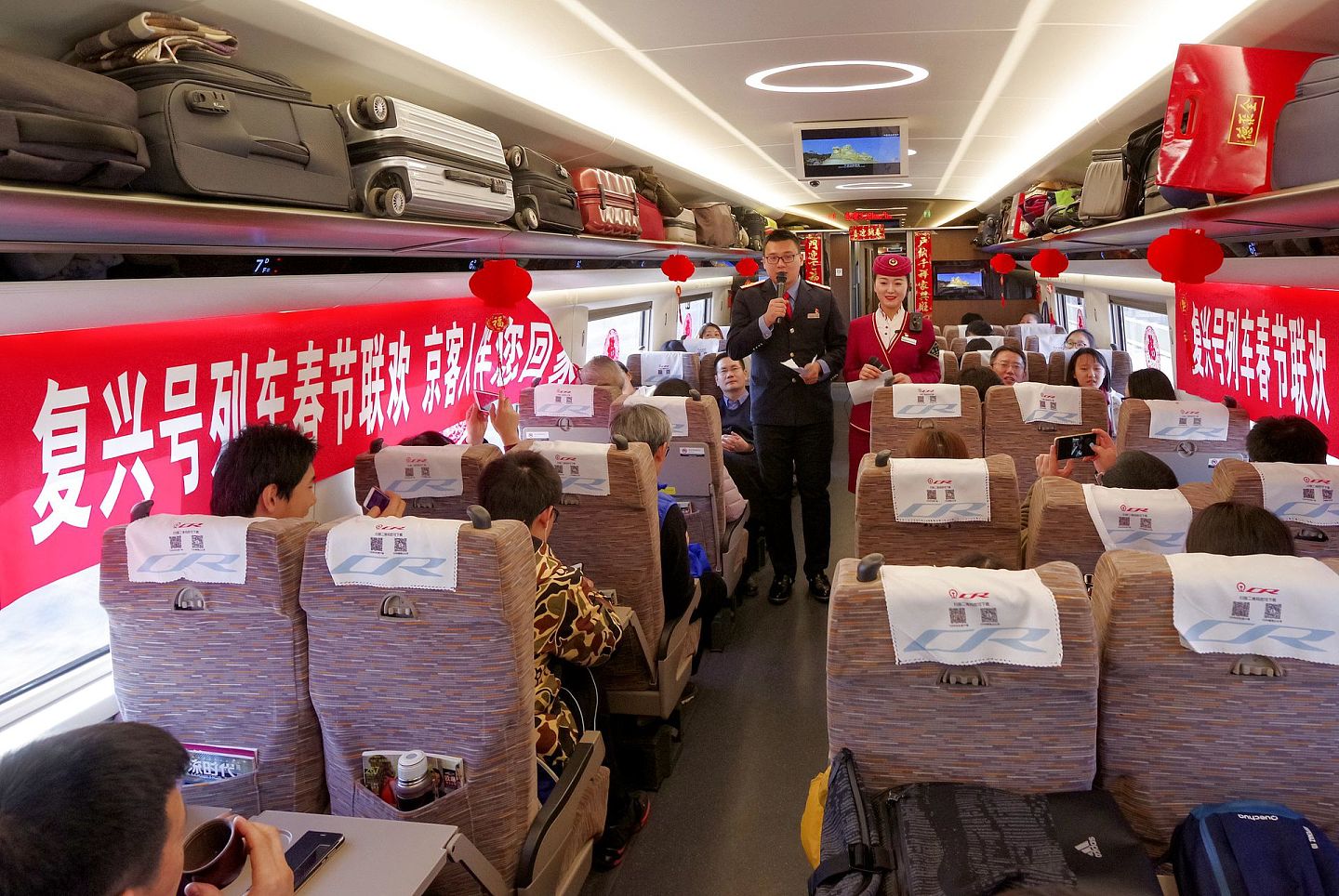 2018年2月13日，从北京南开往上海虹桥的G13次“复兴号”动车组列车上，一场车厢里的春节联欢会正在上演。（视觉中国）