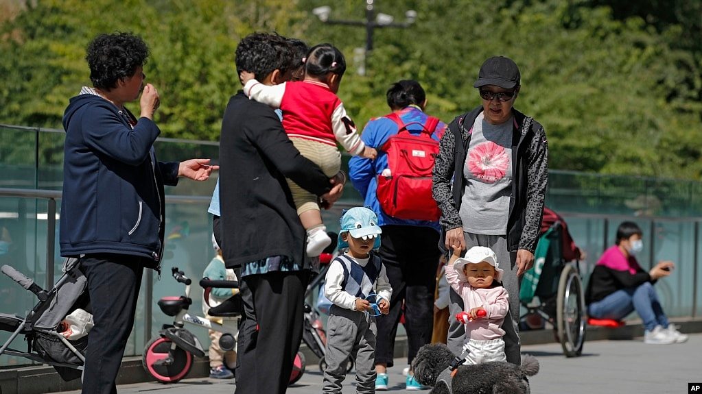 北京市民带着孩子在一处商业大楼广场上游玩。（2021年5月10日）