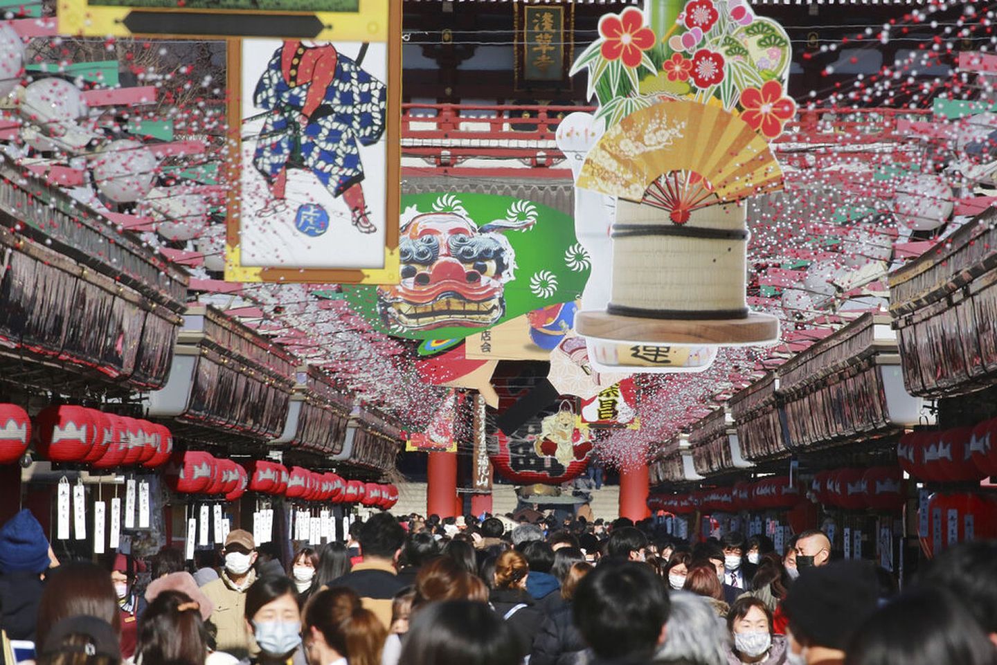 日本新冠肺炎疫情：图为2021年12月21日，人们走在日本浅草寺外的街道上。路上的装饰已甚富新年气氛。（AP）
