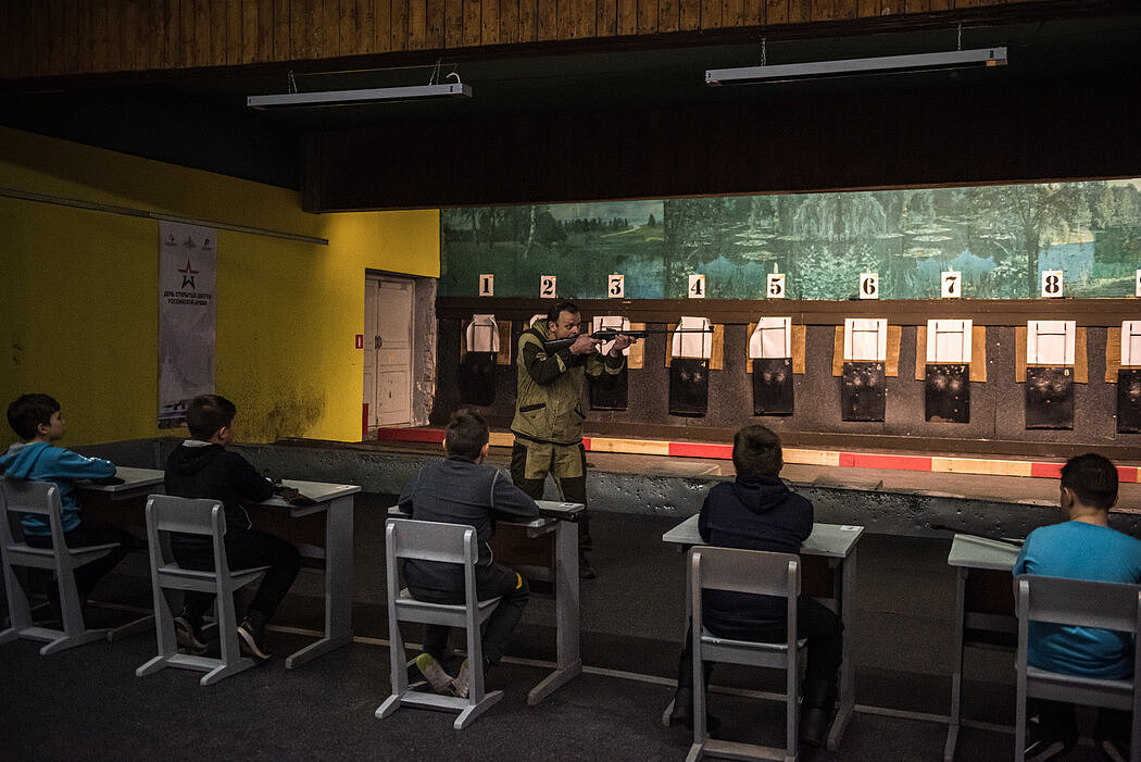 在诺金斯克的训练中心，一名教师在向孩子们展示如何使用气枪。