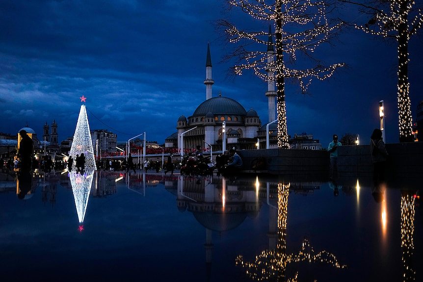 A Christmas tree is lit up in white lights next to Taksim mosque at Taksim square in Istanbul, Turkey