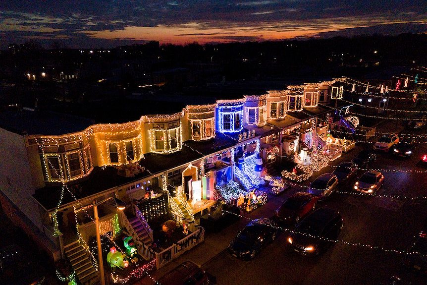 an aerial shot of a string of houses illuminated in christmas lights in Baltimore, US