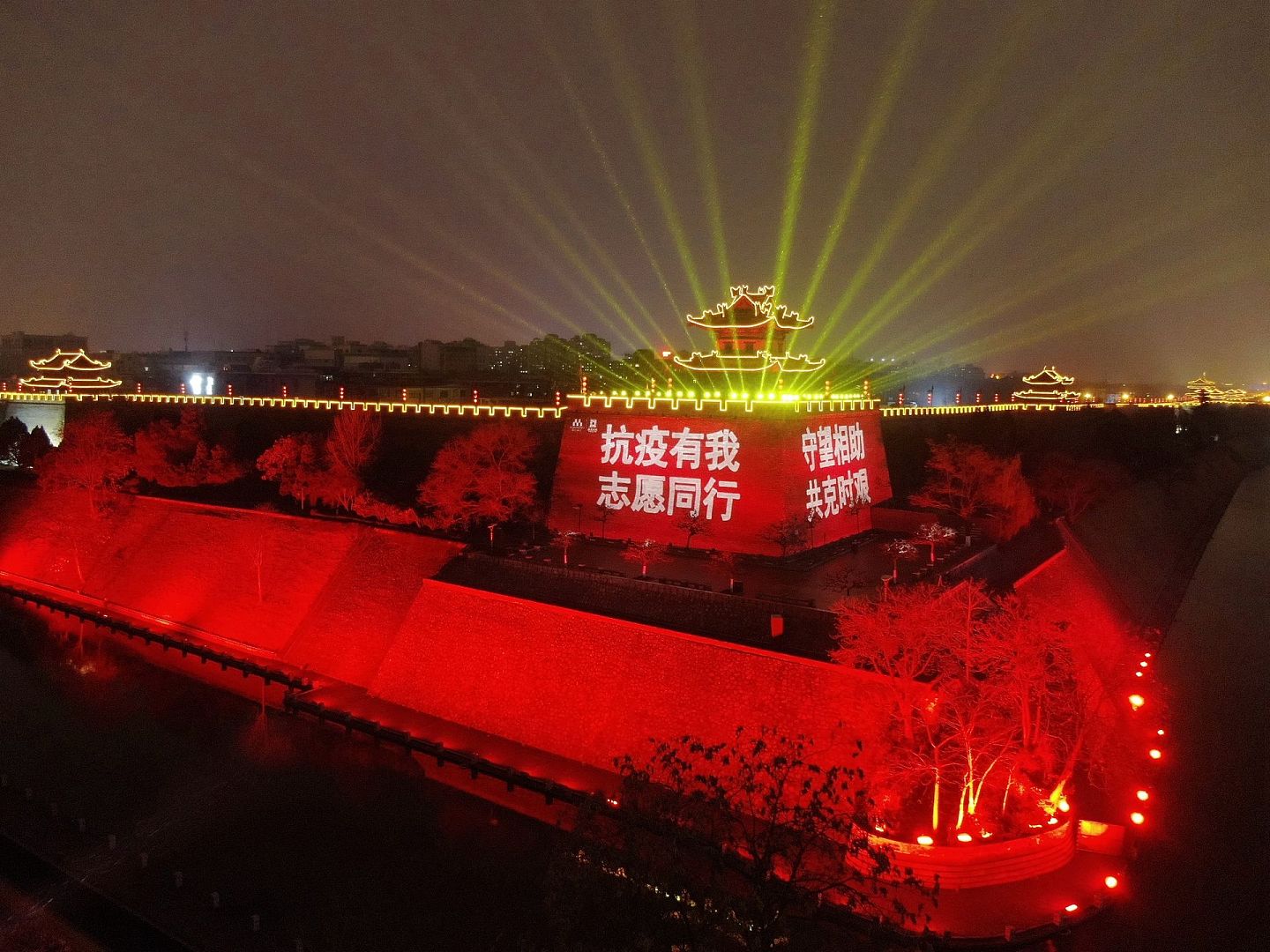 2021年12月25日，西安明城墙点亮夜景灯光，打出“西安加油”“守望相助”等字样，为抗击新冠肺炎疫情加油鼓劲。（新华社）