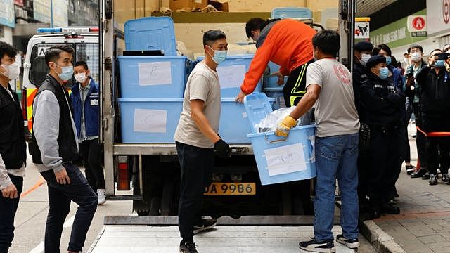 香港观塘《立场新闻》办公室所在大楼外警员把查抄证物搬上货车（29/12/2021）