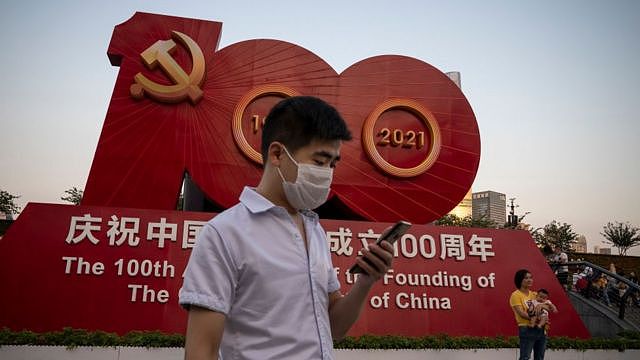 在上海，人们在庆祝中国共产党成立100周年的标志前拍照。