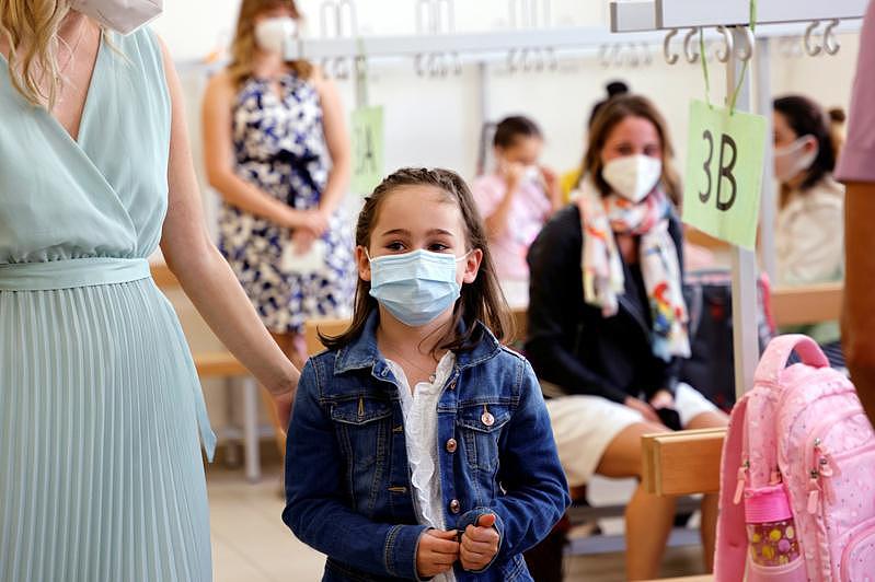 奥地利维也纳儿童和家长在一所小学戴口罩等待接受抗原快筛。（路透）