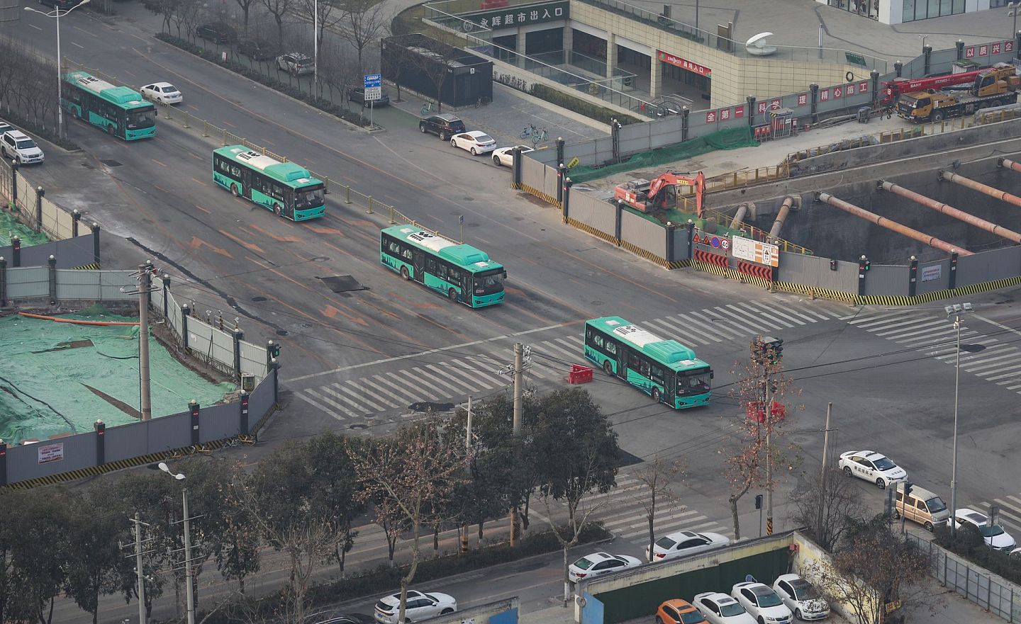 着眼于西安疫情及相关措施，中国因为几十个病例就封城，“这让西方世界许多地方的人都觉得不可思议”。图为2022年1月3日，西安载有医护人员的公交大巴车驶过十字路口。（人民视觉）