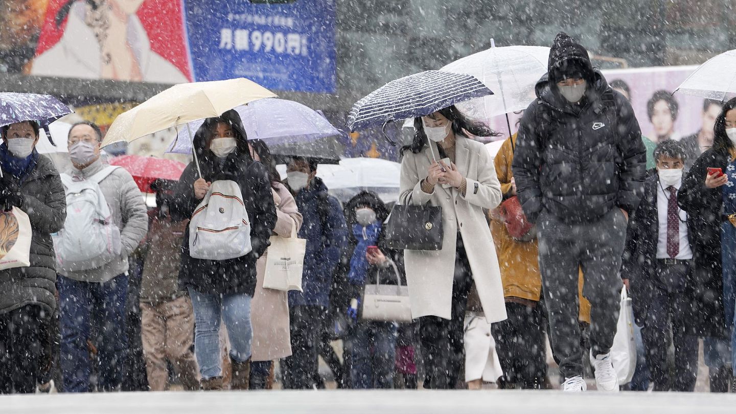 日本新冠肺炎疫情：图为1月6日，日本东京民众在雪中步行。（AP）