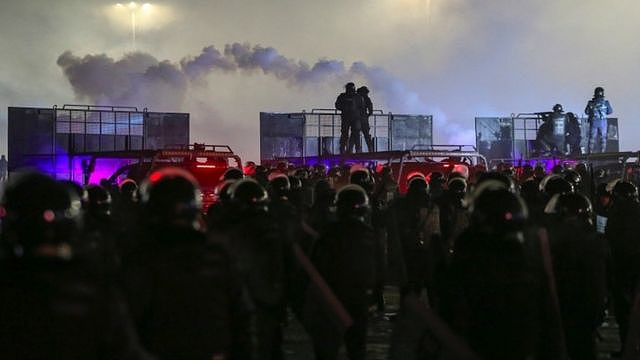 Kazakh law enforcement officers stand guard during a protest in Almaty