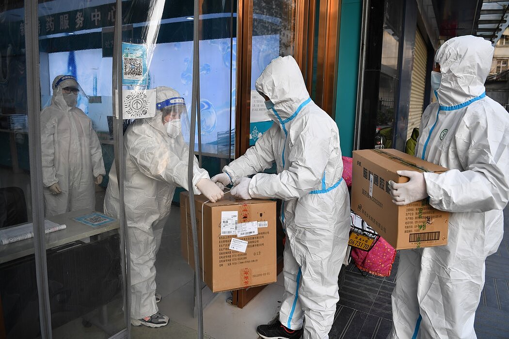 12月，一家制药公司的员工向西安的一家药店运送物资。