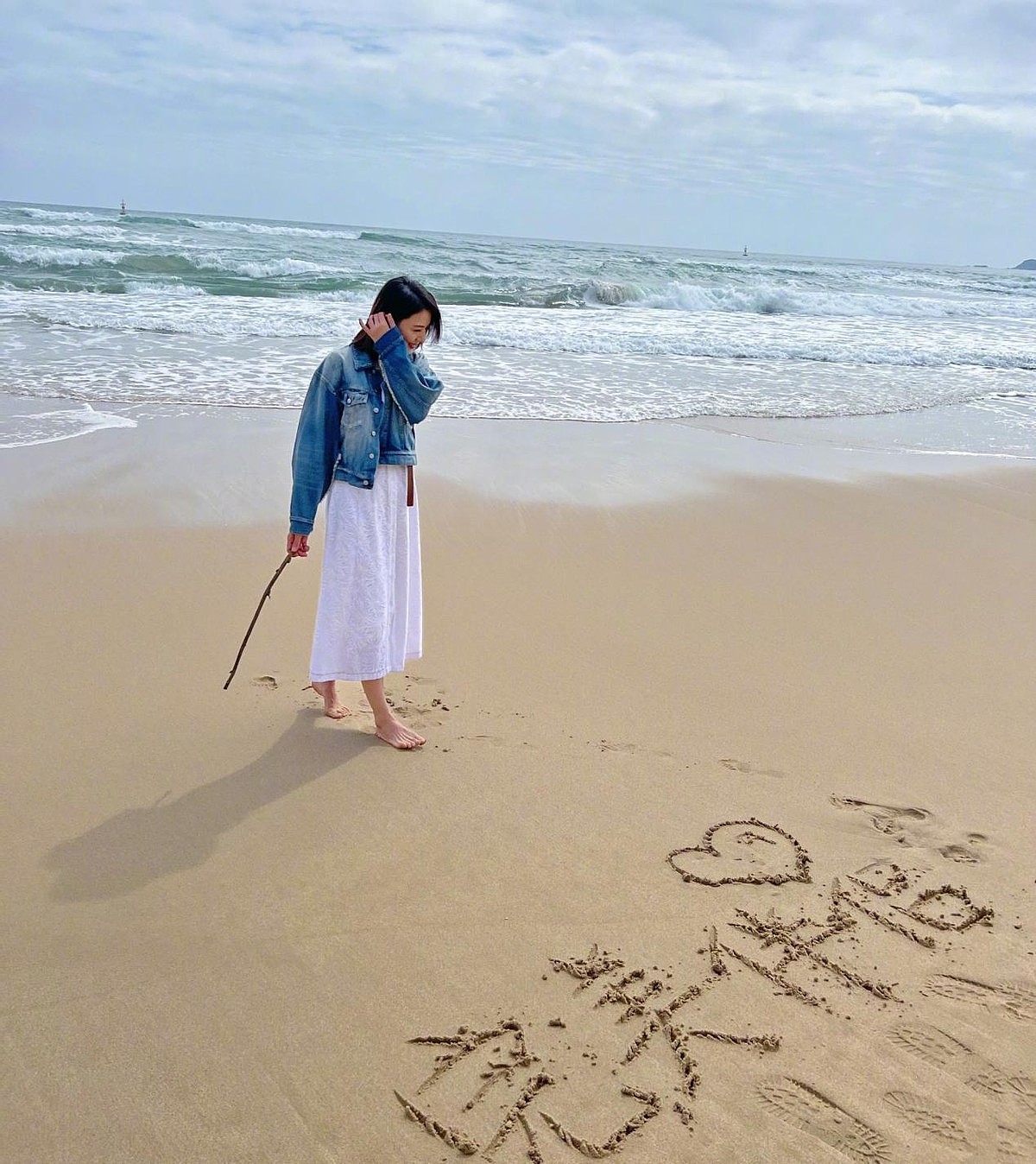 高圆圆赤脚在海边游玩，43岁的她回眸一笑太美，还在沙滩写新剧名