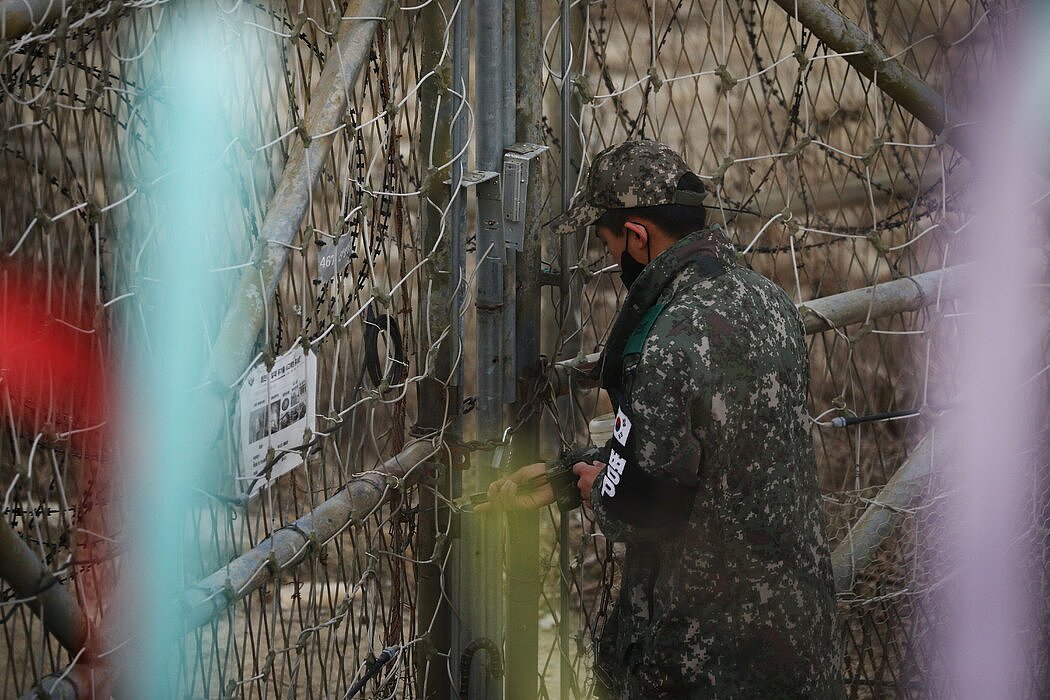 一名士兵在韩国坡州靠近边境的一个哨所把门锁上。