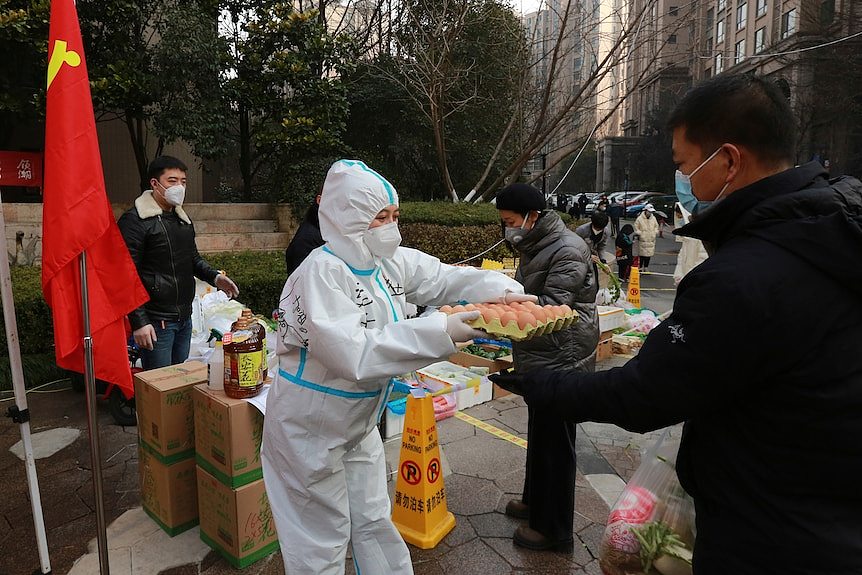 穿着防护服的防疫人员在发鸡蛋