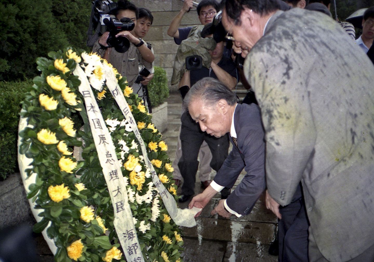 2000年8月15日，日本前总理大臣海部俊树一行冒雨来到大屠杀遇难同胞纪念馆，向纪念碑敬献花圈，并为纪念馆题词：“希望21世纪是和平的世纪”。 图片作者:祁恩芝 刘健芝/视觉中国