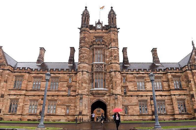 Students walk around the University of Sydney campus on a rainy day.