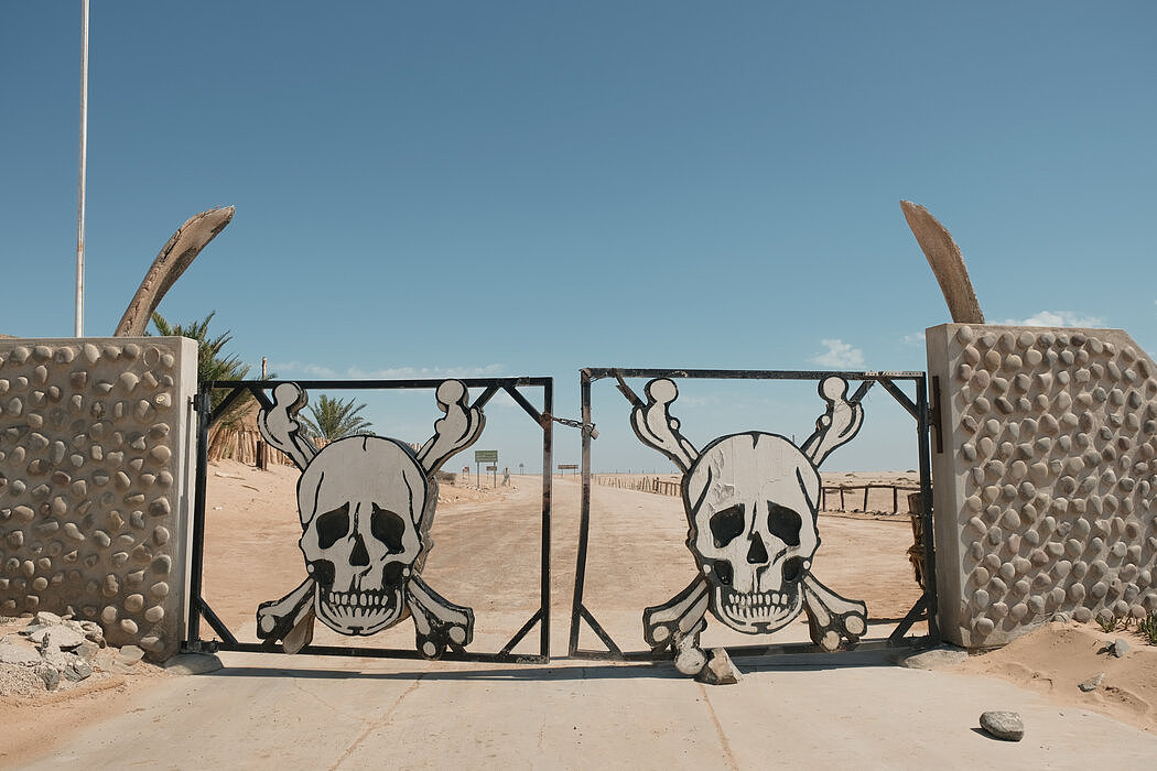 骷髅海岸国家公园的南入口乌加布门上装饰着一对头骨和鲸骨，以警告游客经过后将面临恶劣环境。