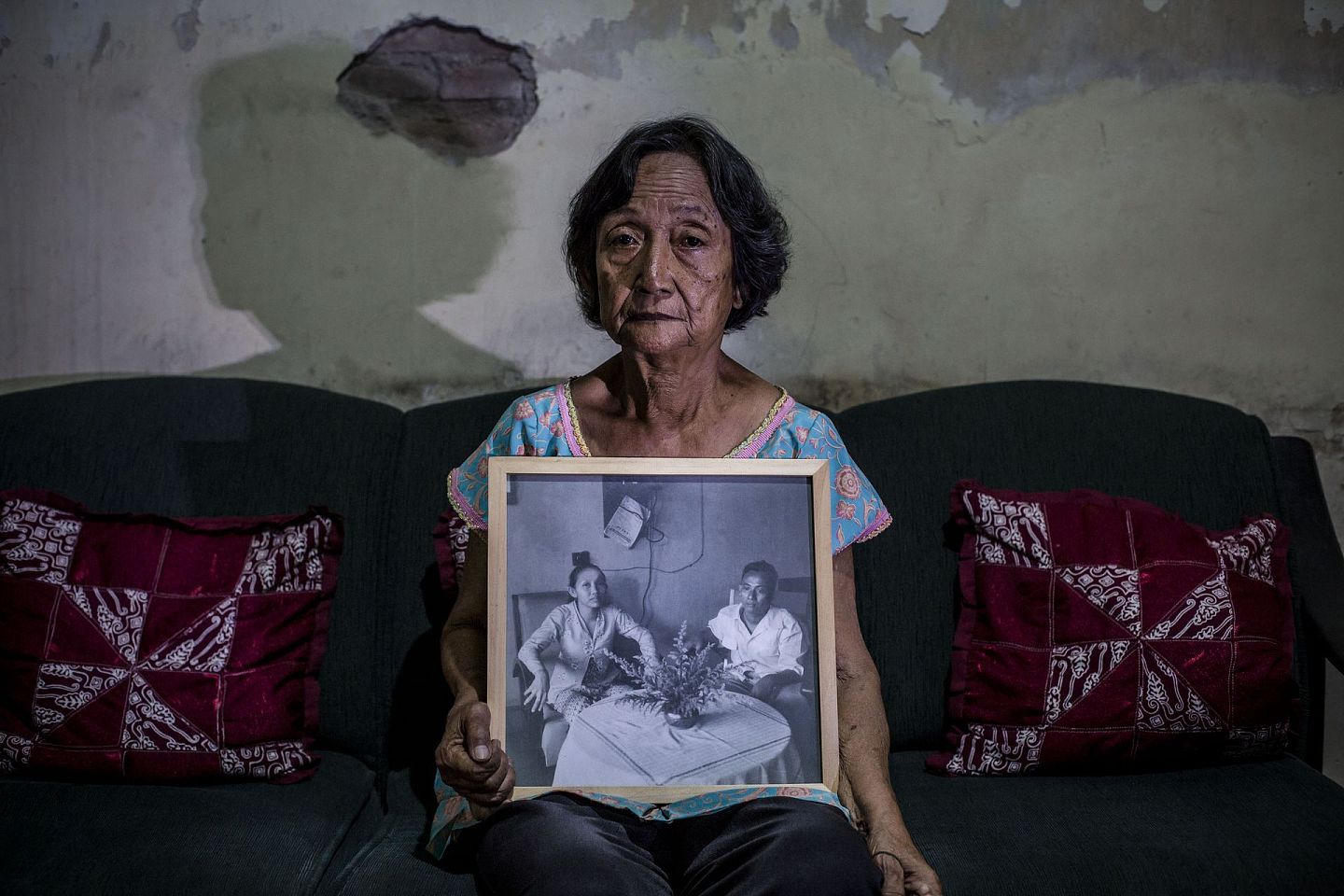 印尼大屠杀：印尼1965至1966年发生反共排华大屠杀。图为2016年5月6日，印尼日惹一名女子手持父母的照片，她的父亲在反共排华大屠杀期间被指与印尼共产党有关，他最终被杀。（Getty）