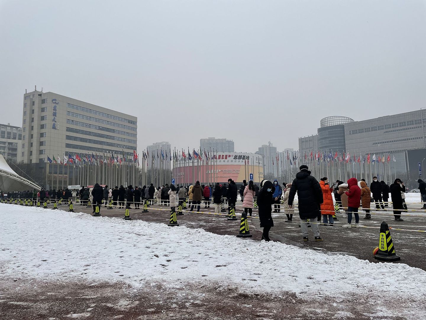 2022年1月24日，北京市丰台区总部基地招商中心核酸检测点，市民雪中有序排队接受核酸检测。（视觉中国）
