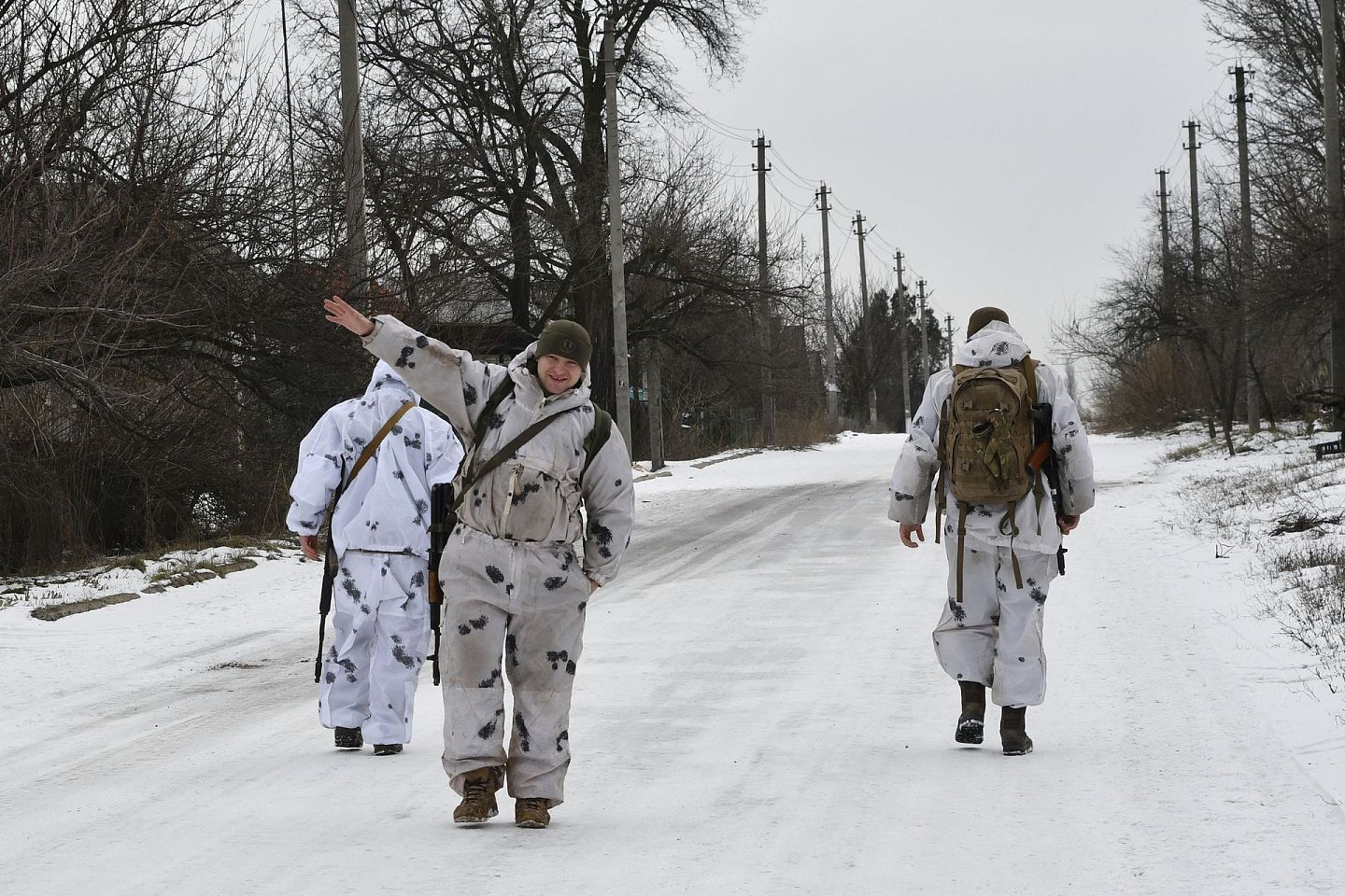 2022年1月22日，在乌克兰东部顿涅茨克地区，一名乌克兰军人和他的战友在一条街道上与俄罗斯支持的分离主义分子一起向前线巡逻时挥手致意。（AP）
