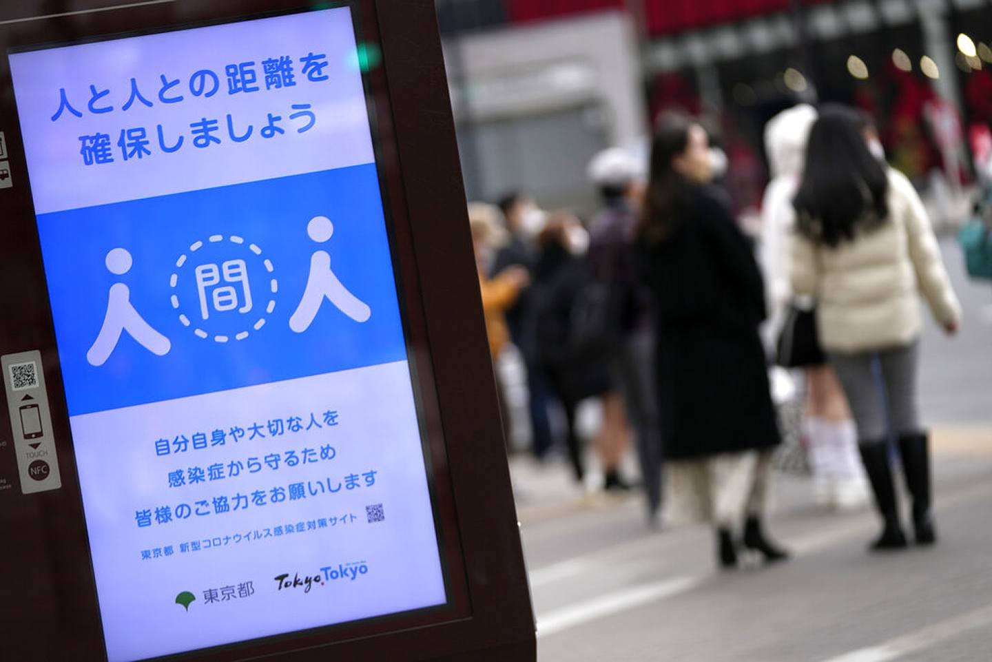 日本新冠肺炎疫情：图为1月28日，东京街头一块标语牌提醒民众维持社交距离。 （AP）