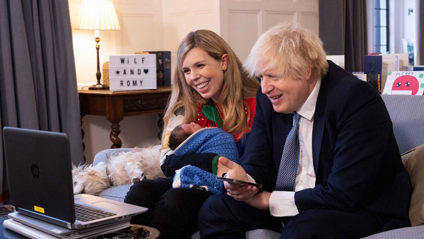 圖為英國首相約翰遜（右）的妻子西蒙茲（左）抱着女兒羅米。夫婦倆面對手提電腦屏幕，進行視像通訊。（英國首相府）
