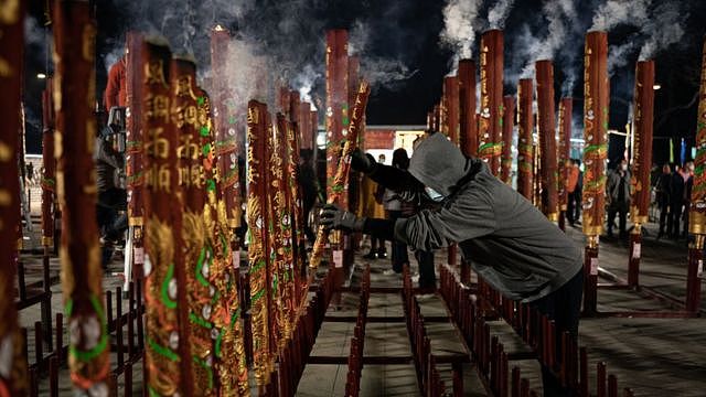 一名男子在香港一座寺庙供香。