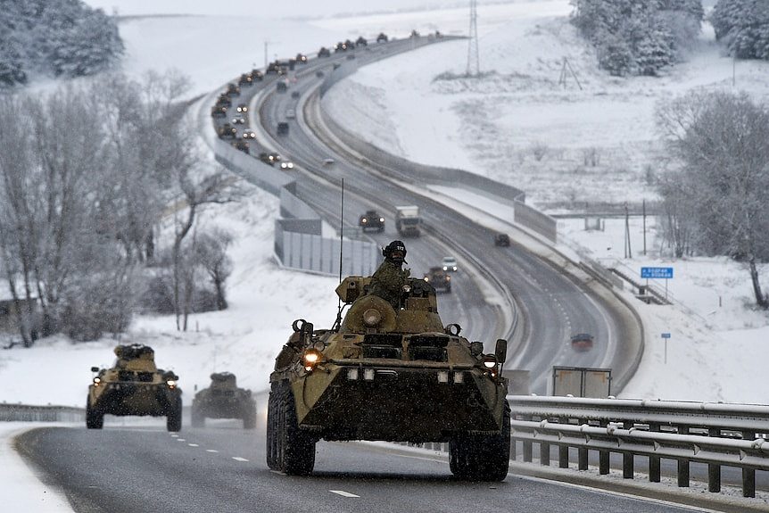 A convoy of Russian armored vehicles moves along a highway in Crimea