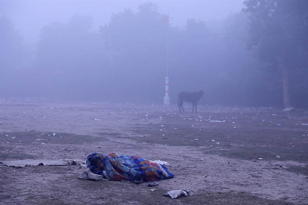 第二大城德里(Delhi)纷纷传出街友受冻路边没了呼吸心跳。 图为一名街友无家可归只能睡在路旁。 (图/路透社)