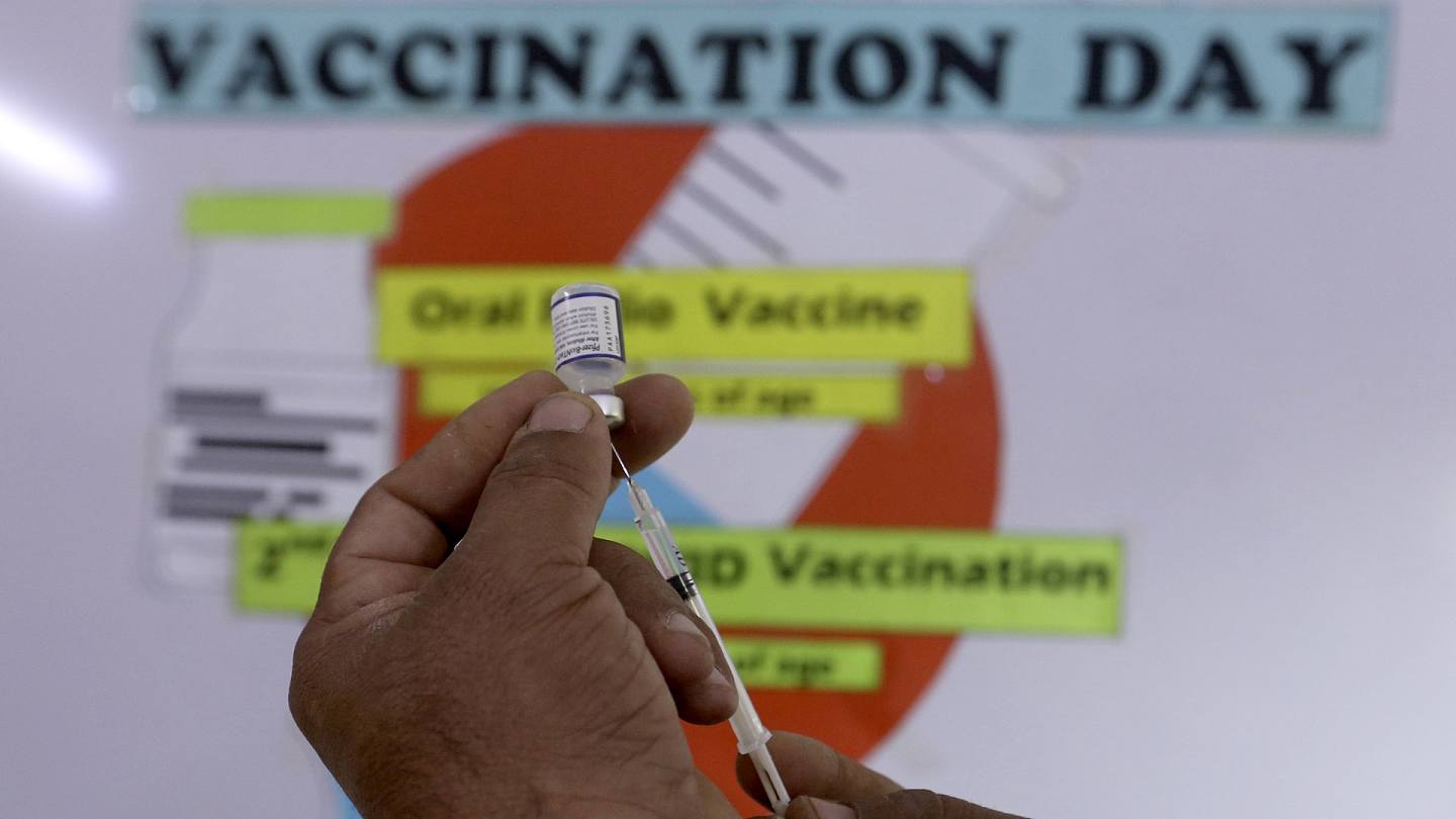 新冠疫苗：图为2022年1月24日，巴基斯坦卡拉奇一名医护人员准备为学生接种新冠疫苗。 （AP）