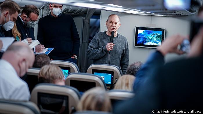 肖尔茨在飞往华盛顿的飞机上回答媒体代表提问。