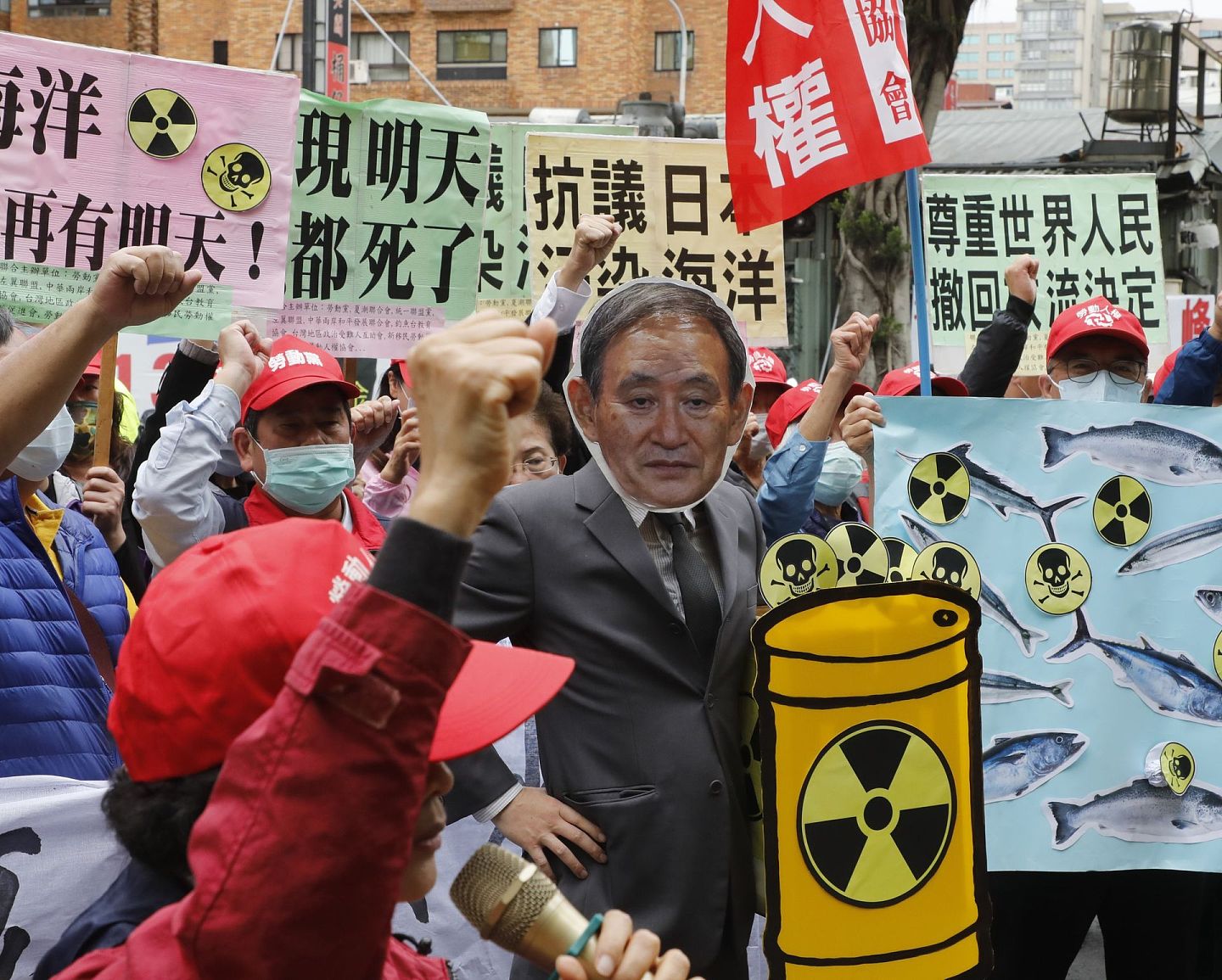 现场上演行动剧，台湾抗议人士扮演日本前首相菅义伟将核废水倒入海洋，让鱼类染上放射性的核污染，表达对生态链污染的忧虑。（多维新闻）