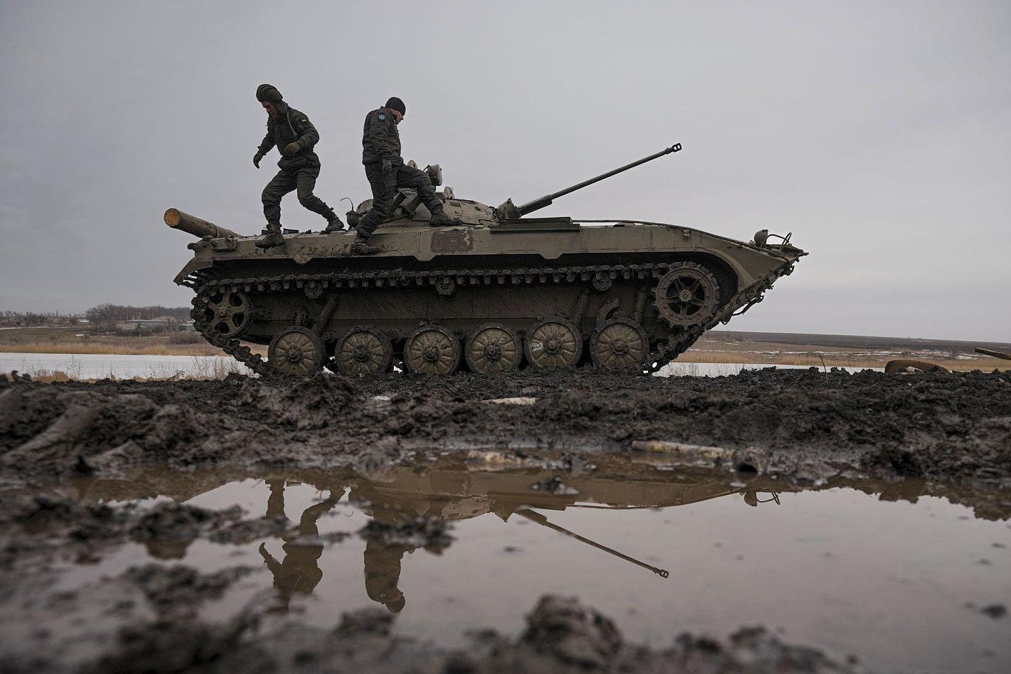 2022年2月10日，乌克兰军人在乌克兰东部顿涅茨克地区联合部队行动控制区的一次演习中走在装甲战车上。（美联社）
