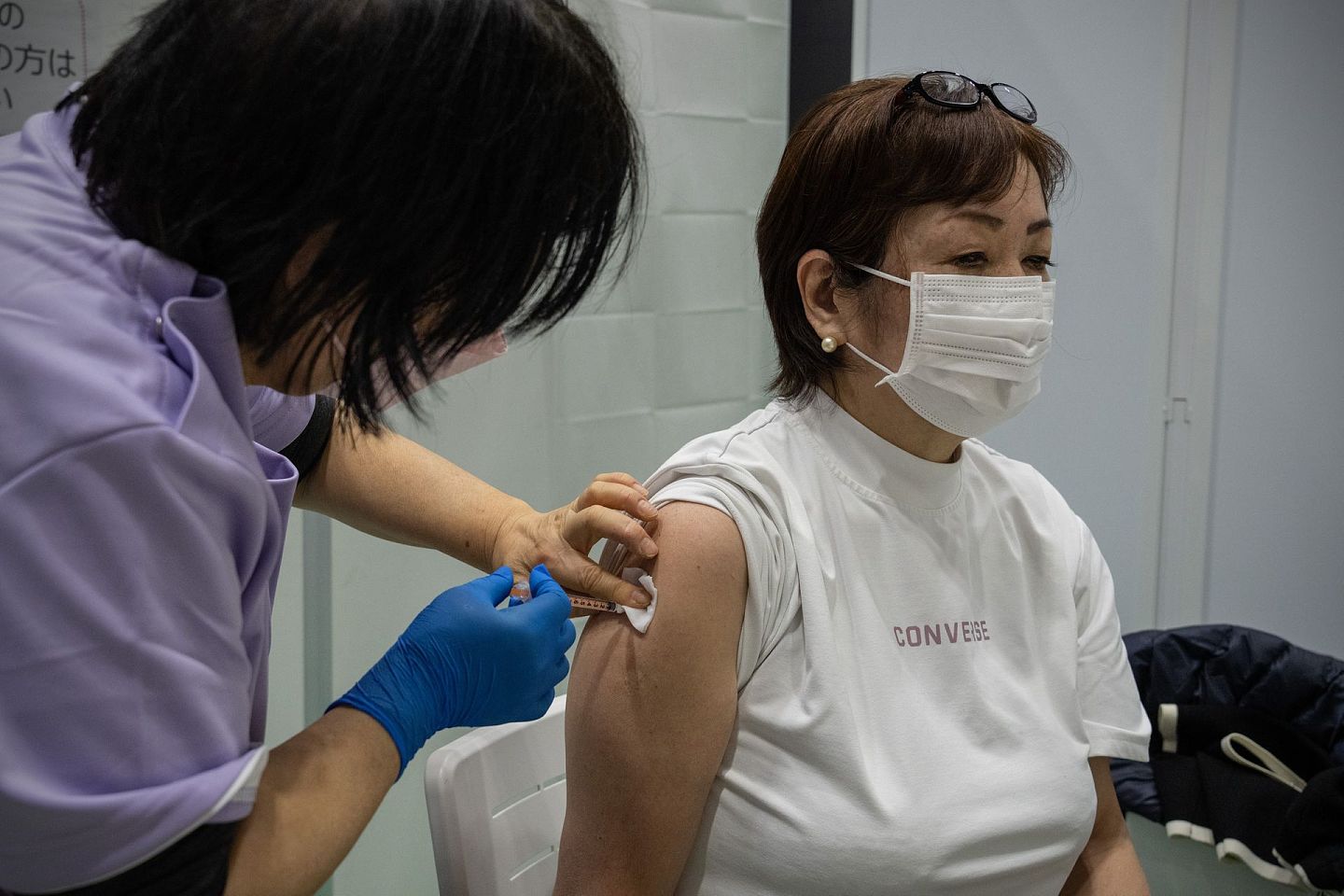 图为1月20日，日本东京一间疫苗中心，医护人员正为市民接种疫苗。（Getty）
