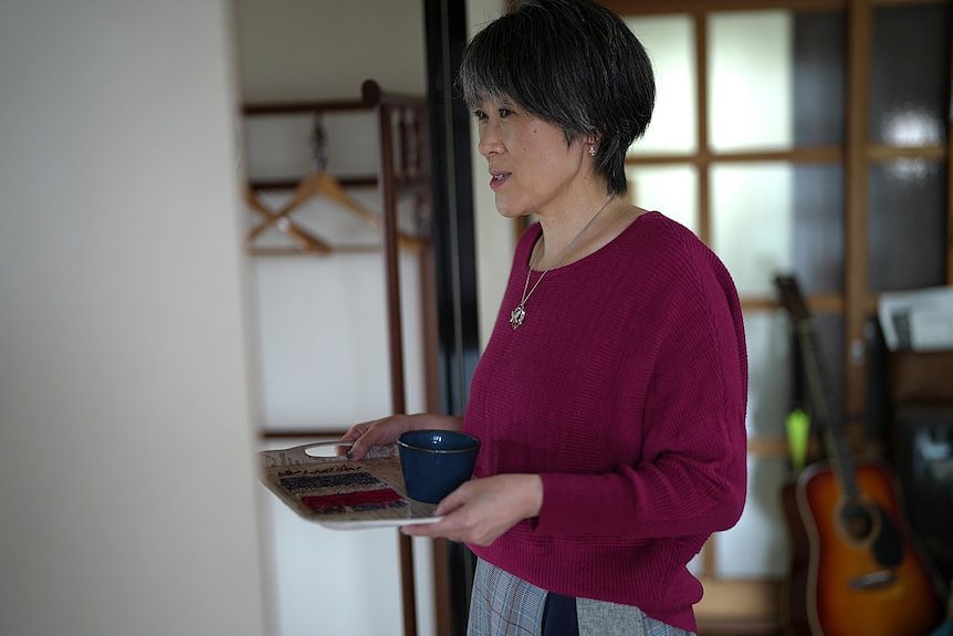 A woman carries a tray.