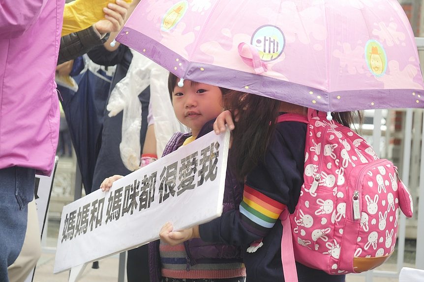 A Taiwanese child holds a sign reading, 
