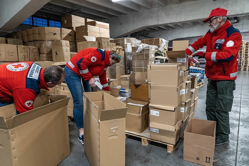 卢布林的波兰红十字会志愿者将一箱箱食物和必需品打包，配发到乌克兰边境的难民中心。