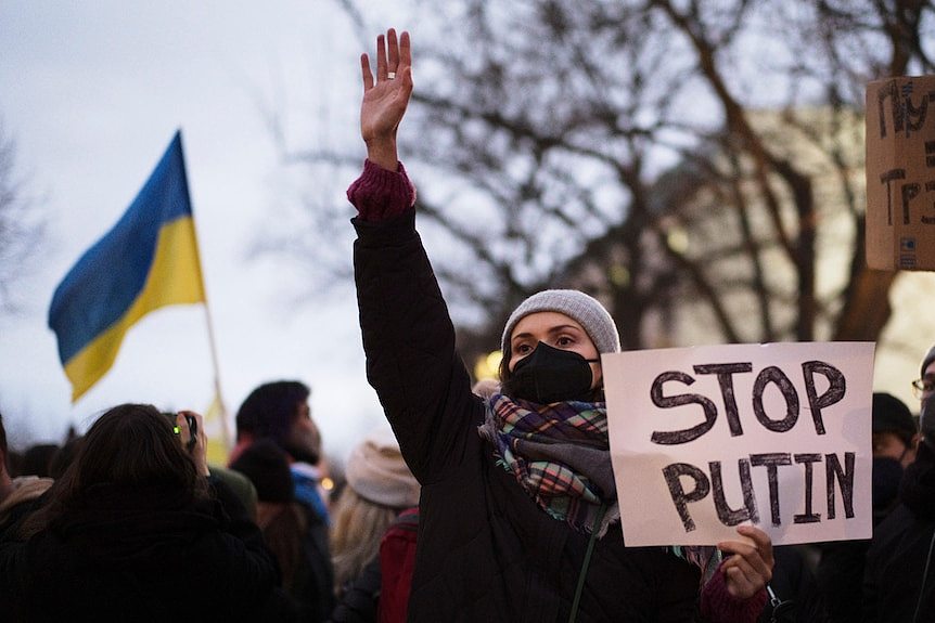 A woman holds a sign that reads 