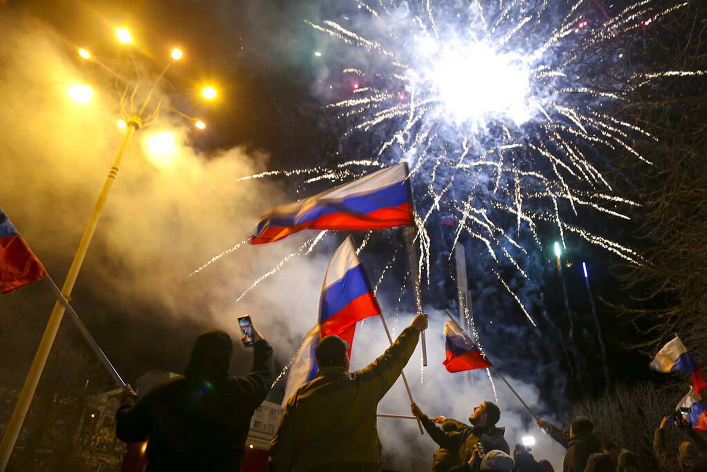 顿涅茨克地区有人上街挥舞俄罗斯国旗，庆祝该地独立获得普京承认。（AP）