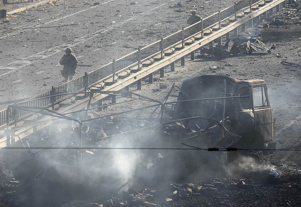 乌克兰士兵2月26日行经首都基辅街头烧得焦黑的军车旁。 （美联社）