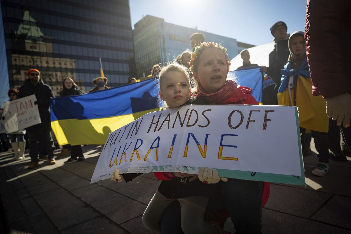 2月24日，在不列颠哥伦比亚省温哥华举行的支持乌克兰人民的集会上，一名妇女和一名幼儿举着牌子。（AP）