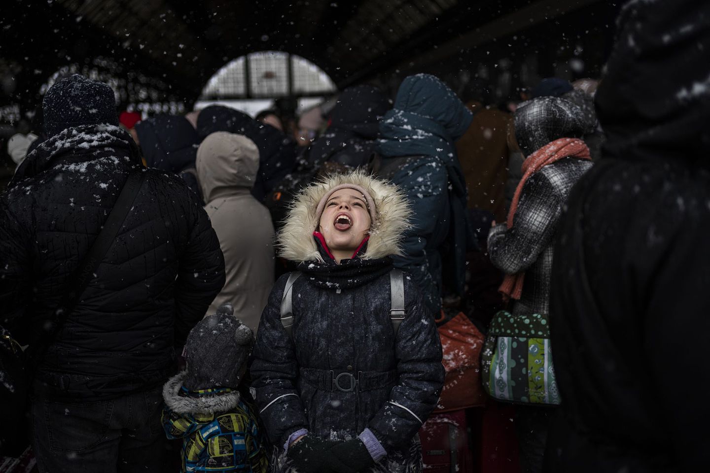2022年2月27日，在乌克兰西部的利沃夫火车站，一名女孩在等待登上开往波兰的火车时抓住了雪花。（AP）