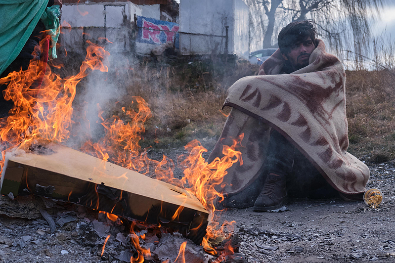 图为一名逃至波兰的乌克兰难民，在寒冬中生火取暖。 新华社