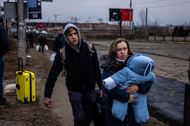 乌克兰一名妇女7日带着孩子逃离首都基辅西北的伊尔平（Irpin）。 (Getty Images)