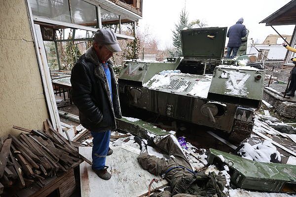 ▲▼乌克兰首都基辅附近，一名男子看着躺在军车旁的俄罗斯士兵遗体。（图／达志影像／美联社）