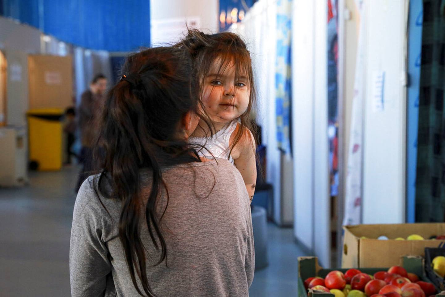 乌克兰局势：图为2022年3月12日，摩尔多瓦一间难民中心内，一名逃离乌克兰的女子抱着一名女童。 （AP）
