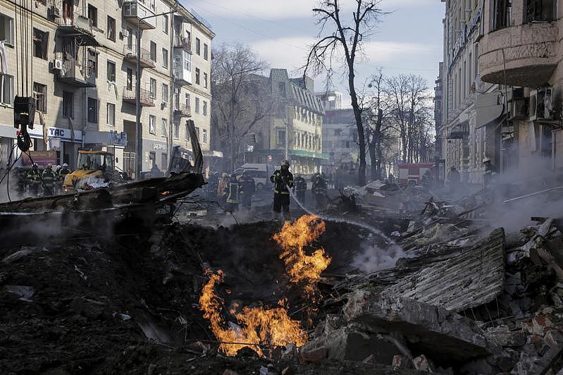 乌克兰第二大城哈尔科夫遭俄军连日轰炸，图为一名乌克兰消防员14日在为被炸毁的公寓灭火。 (美联社)