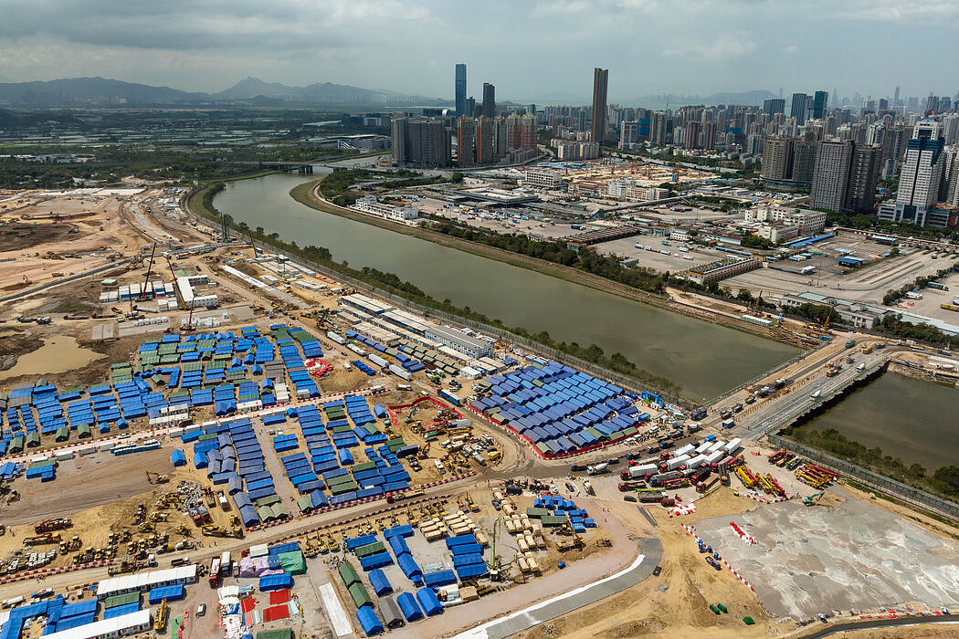 香港，一座正在建设中的用于接收新冠患者的临时隔离设施。该设施旁边是一座跨越深圳河、连接香港与中国大陆的临时桥梁。